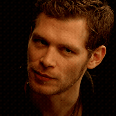 A Close Up Of A Young Man 'S Face With A Black Background GIF