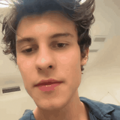 A Close Up Of A Young Man 'S Face With A Blue Shirt GIF