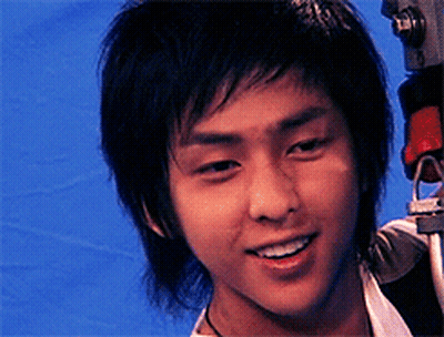 A Close Up Of A Young Man 'S Face With A Camera In The Background GIF