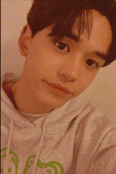 A Close Up Of A Young Man 'S Face With A Candle In The Background GIF