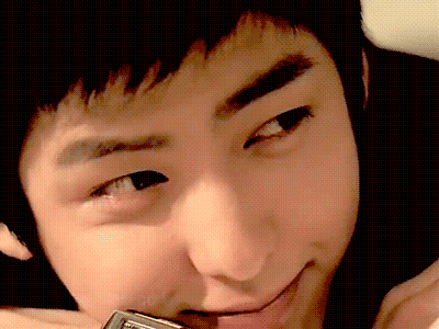 A Close Up Of A Young Man 'S Face With A Cell Phone In His Mouth GIF