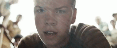 A Close Up Of A Young Man 'S Face With A Crowd Of People Behind Him . GIF