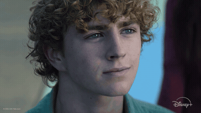 A Close Up Of A Young Man 'S Face With A Disney Logo In The Background GIF