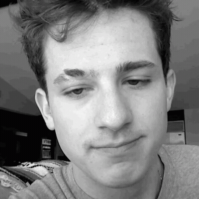 A Close Up Of A Young Man 'S Face With A Gray Shirt On GIF