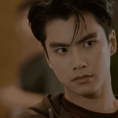 A Close Up Of A Young Man 'S Face With A Hand On His Chin GIF
