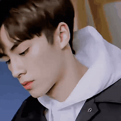 A Close Up Of A Young Man 'S Face With A Hoodie On . GIF