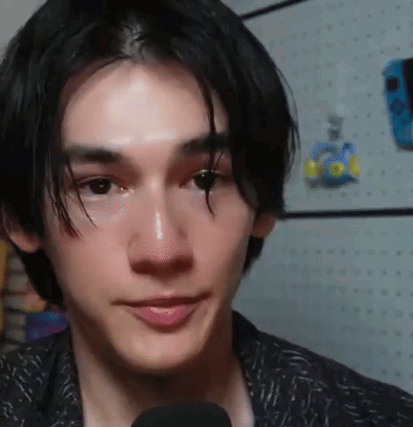 A Close Up Of A Young Man 'S Face With A Microphone . GIF