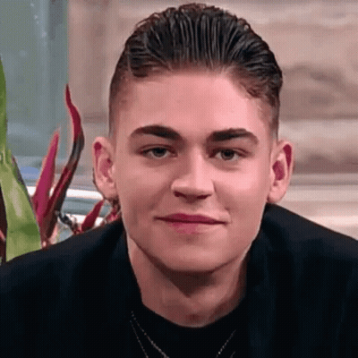 A Close Up Of A Young Man 'S Face With A Necklace Around His Neck . GIF