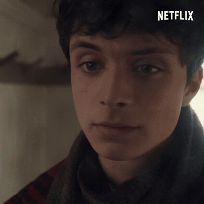 A Close Up Of A Young Man 'S Face With A Netflix Logo In The Background GIF