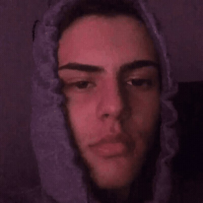 A Close Up Of A Young Man 'S Face With A Purple Background . GIF