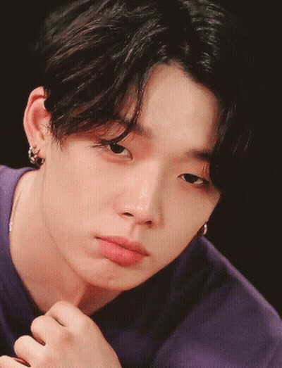 A Close Up Of A Young Man 'S Face With A Purple Shirt On GIF