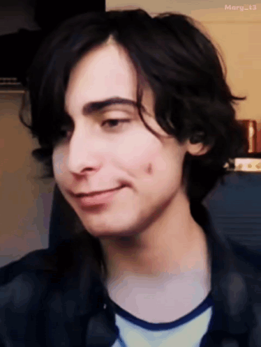A Close Up Of A Young Man 'S Face With A Slight Smile GIF