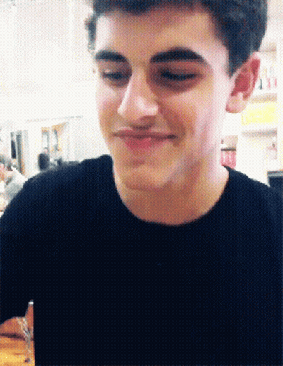 A Close Up Of A Young Man 'S Face With A Smile On His Face GIF
