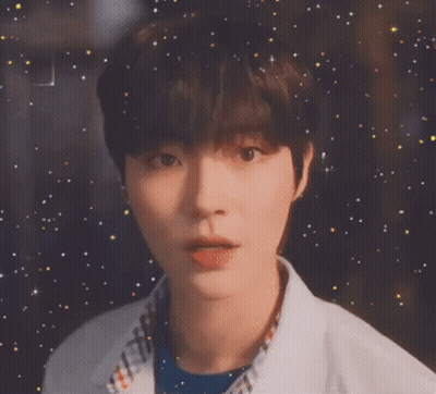 A Close Up Of A Young Man 'S Face With A Starry Background GIF