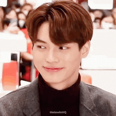 A Close Up Of A Young Man 'S Face With A Turtleneck And A Suit . GIF