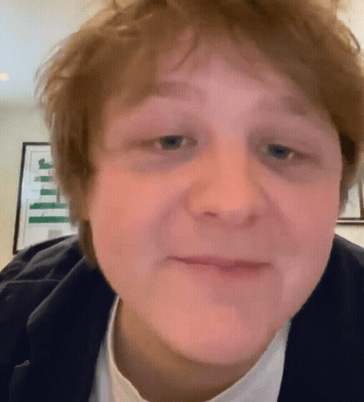 A Close Up Of A Young Man 'S Face With A White Shirt And A Black Jacket GIF