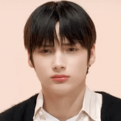 A Close Up Of A Young Man 'S Face With A White Shirt And Black Sweater . GIF