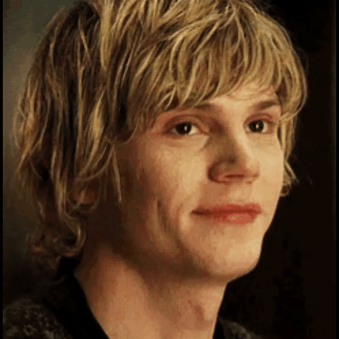 A Close Up Of A Young Man 'S Face With Blonde Hair And A Black Shirt . GIF