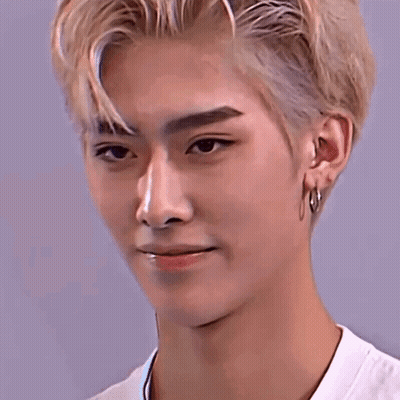 A Close Up Of A Young Man 'S Face With Blonde Hair And Hoop Earrings . GIF