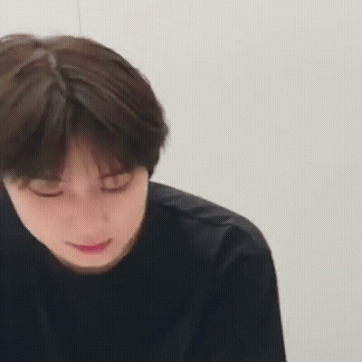 A Close Up Of A Young Man 'S Face With His Eyes Closed And A Black Shirt On . GIF