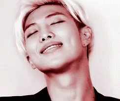 A Close Up Of A Young Man 'S Face With His Eyes Closed And A Smile On His Face . GIF