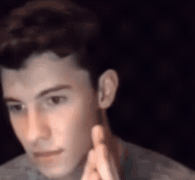 A Close Up Of A Young Man 'S Face With His Hands Folded In Prayer . GIF