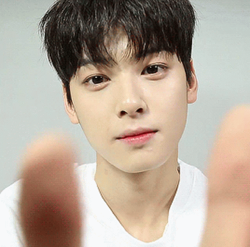 A Close Up Of A Young Man 'S Face With His Hands In Front Of Him GIF
