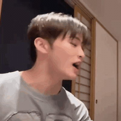 A Close Up Of A Young Man 'S Face With His Mouth Open . GIF