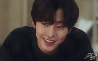 A Close Up Of A Young Man Smiling And Touching His Face . GIF