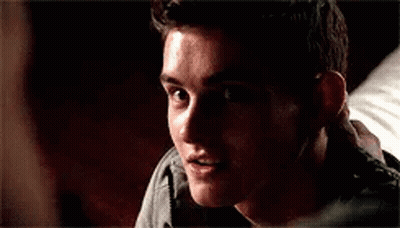 A Close Up Of A Young Man Smiling In A Dark Room . GIF