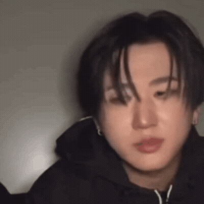 A Close Up Of A Young Man Wearing A Black Hoodie And Earrings . GIF