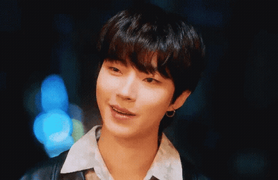 A Close Up Of A Young Man Wearing A Black Jacket And Earrings . GIF