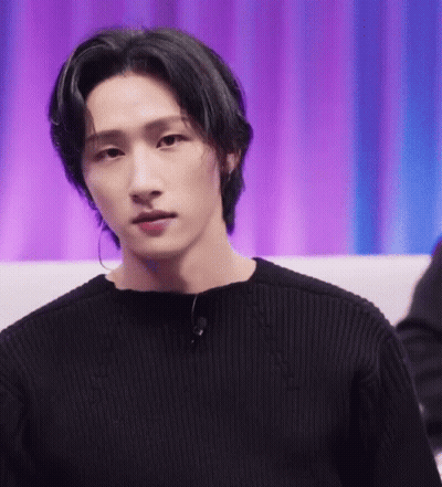 A Close Up Of A Young Man Wearing A Black Sweater And Earrings . GIF