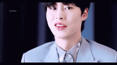 A Close Up Of A Young Man Wearing A Blue Suit And White Shirt . GIF
