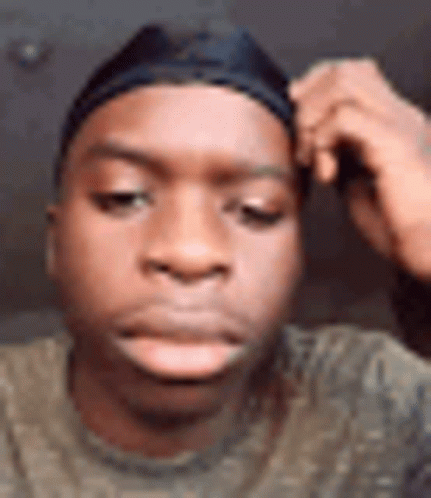 A Close Up Of A Young Man Wearing A Headband And A Hat . GIF