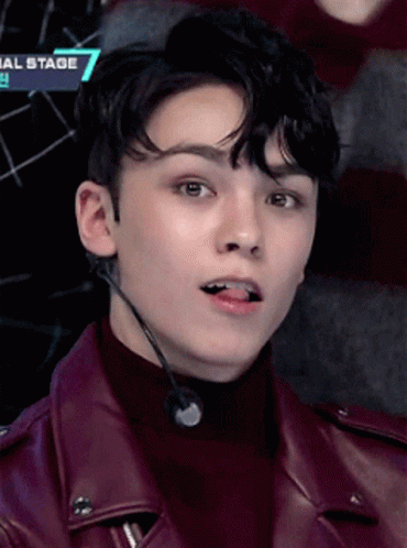 A Close Up Of A Young Man Wearing A Leather Jacket And A Microphone With The Number 7 On It GIF