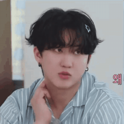 A Close Up Of A Young Man Wearing A Striped Shirt And Earrings . GIF