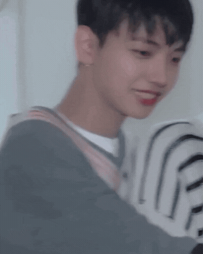 A Close Up Of A Young Man Wearing A Striped Sweater And A White Shirt . GIF