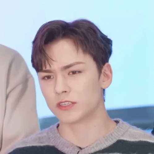 A Close Up Of A Young Man Wearing A Striped Sweater . GIF