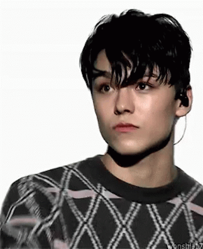 A Close Up Of A Young Man Wearing A Sweater And Earbuds . GIF