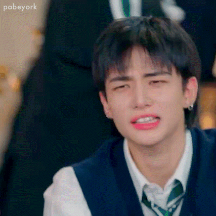 A Close Up Of A Young Man Wearing A Vest And Tie Making A Funny Face . GIF