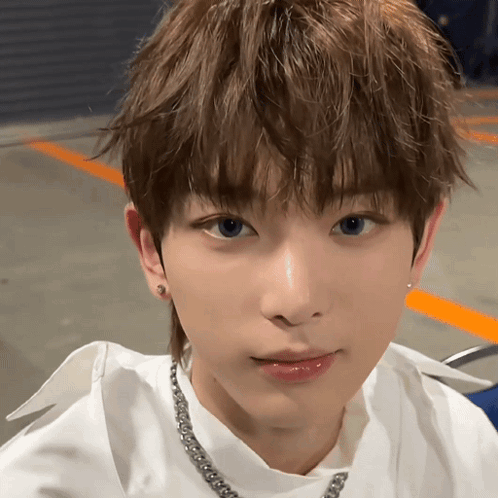 A Close Up Of A Young Man Wearing A White Shirt And A Necklace GIF