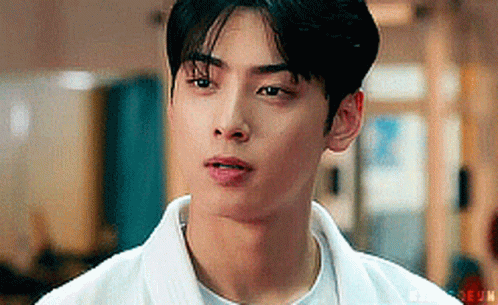 A Close Up Of A Young Man Wearing A White Shirt And A White Jacket . GIF