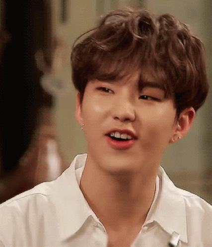 A Close Up Of A Young Man Wearing A White Shirt And Smiling GIF