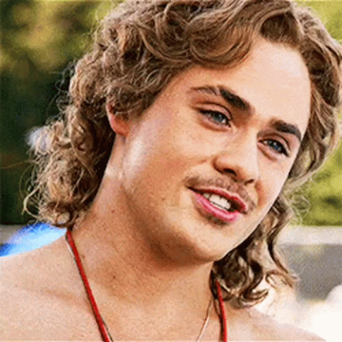 A Close Up Of A Young Man With Curly Hair And A Red Necklace . GIF