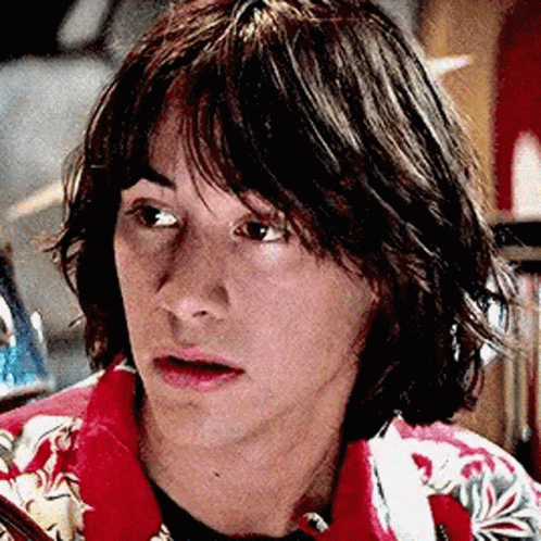 A Close Up Of A Young Man With Long Hair Wearing A Red Jacket And A Blue Shirt . GIF