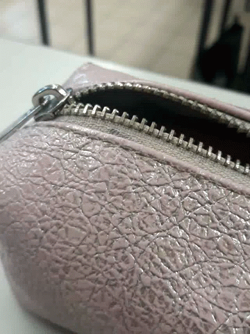 A Close Up Of A Zipper On A Purse GIF