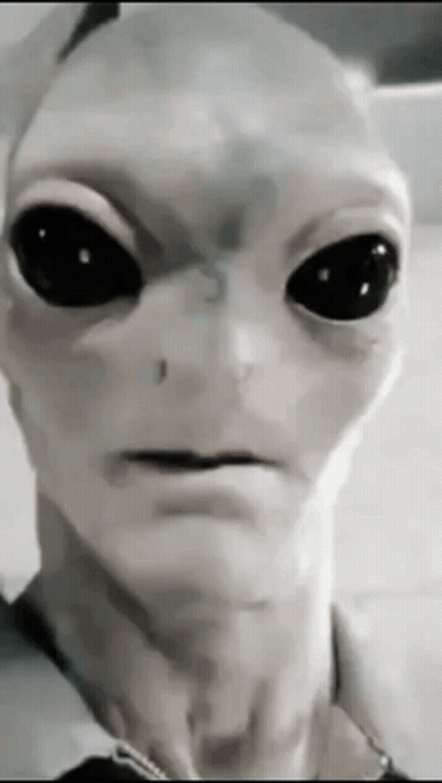 A Close Up Of An Alien With Black Eyes GIF