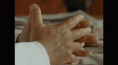 A Close Up Of An Elderly Man 'S Hands On A Bed . GIF