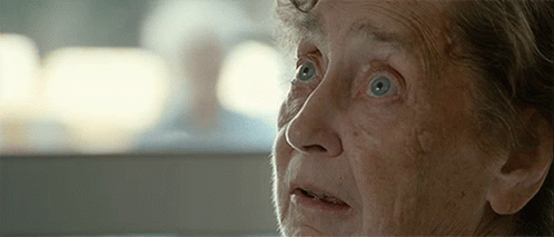 A Close Up Of An Elderly Woman 'S Face With Blue Eyes GIF